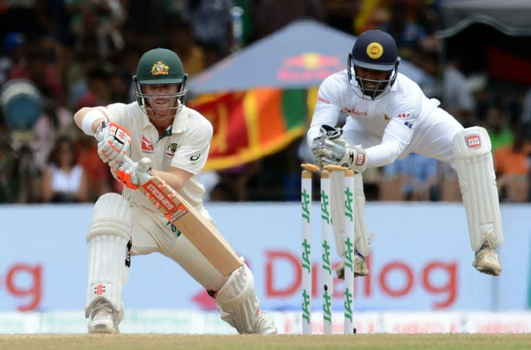 Sri Lanka's wicketkeeper Kusal Perera (R) leaps into the air after an unsuccessfull stumping attempt on Australia's David Warner (L) during the final day of the third Test match in Colombo on August 17, 2016