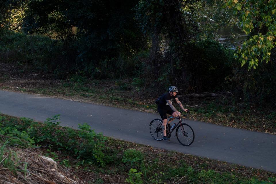A cyclist travels on the French Broad River Greenway, October 3, 2023. The greenway will see a connecting unpaved trail through the city supported program titled AVL Unpaved.