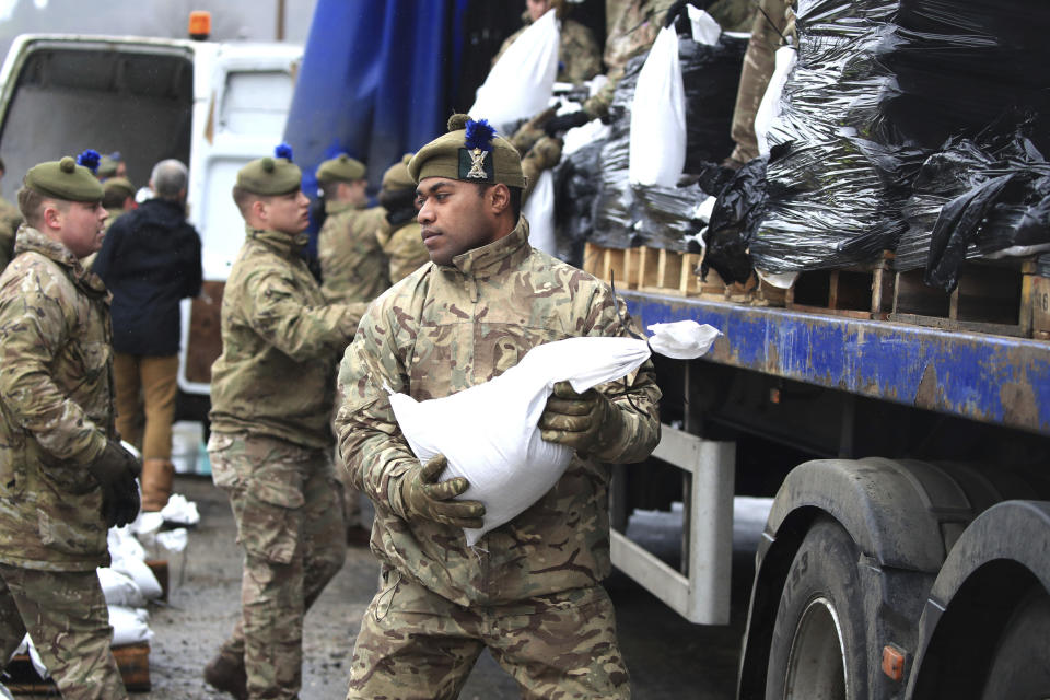 Soldados de los Highlanders, 4to batallón del Real Regimiento de Escocia, asisten con las defensas contra el clima mientras se acerca la tormenta Dennis en Mytholmroyd, West Yorkshire, Inglaterra, el 15 de febrero de 2020. (Danny Lawson/PA via AP)