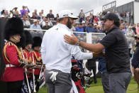 Dustin Johnson of the United States, left, and Phil Mickelson of the United States greet each other on the first tee during the first round of the inaugural LIV Golf Invitational at the Centurion Club in St. Albans, England, Thursday, June 9, 2022. (AP Photo/Alastair Grant)