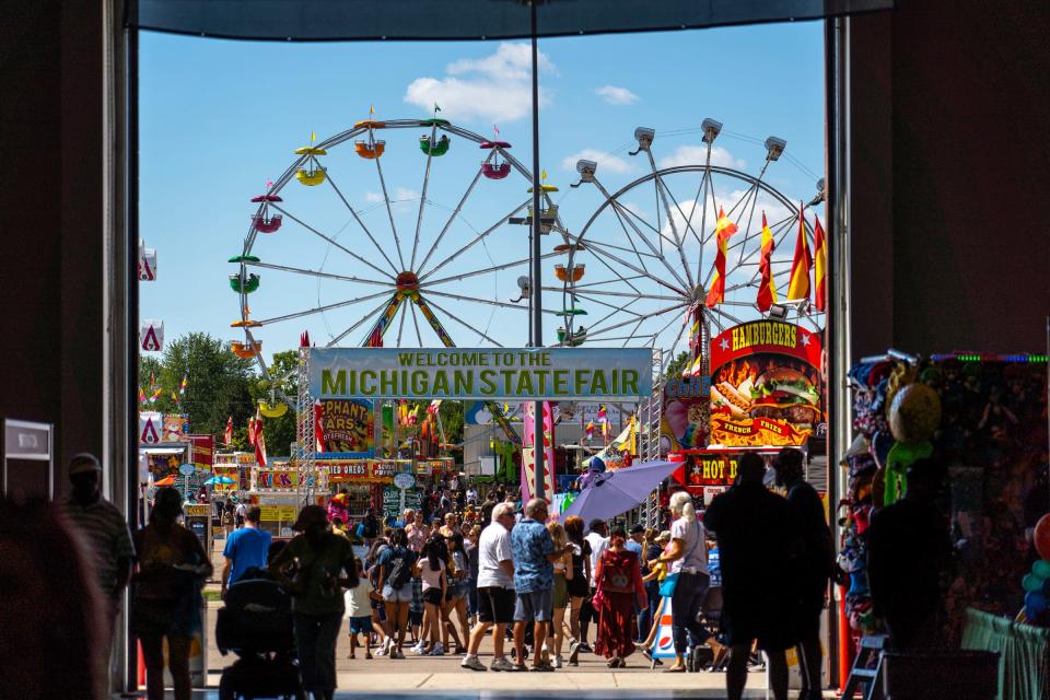 People head to the midway at the Michigan State Fair in Novi at the Suburban Collection Showcase on September 1, 2022.