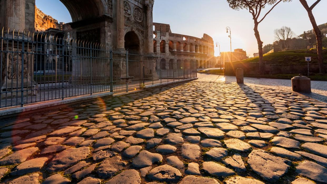 coliseum and arch of constantine at sunrise, rome, italy