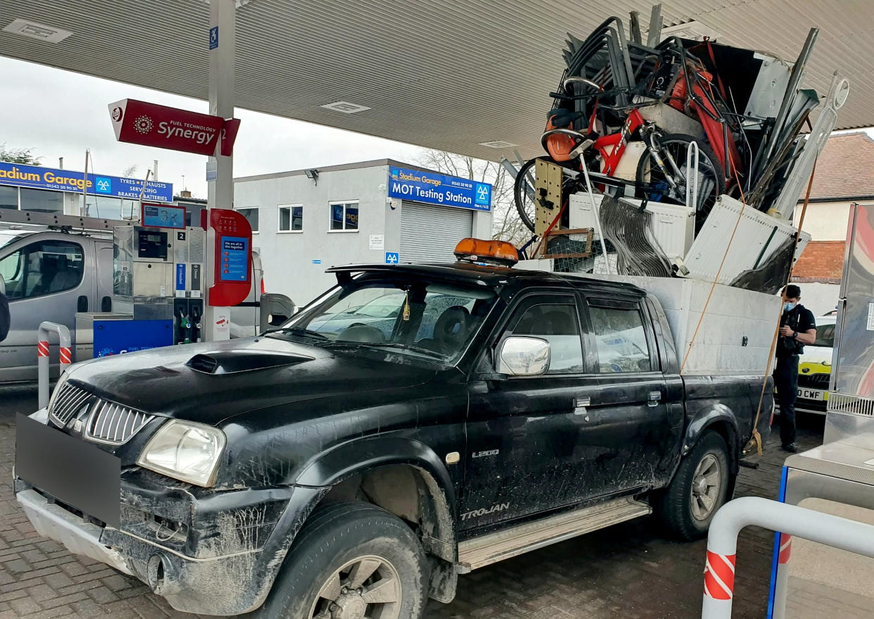 Police were left stunned after pulling over this dangerously overloaded pick-up truck which was piled high with a mountain of rubbish held together by pieces of rope. (SWNS)