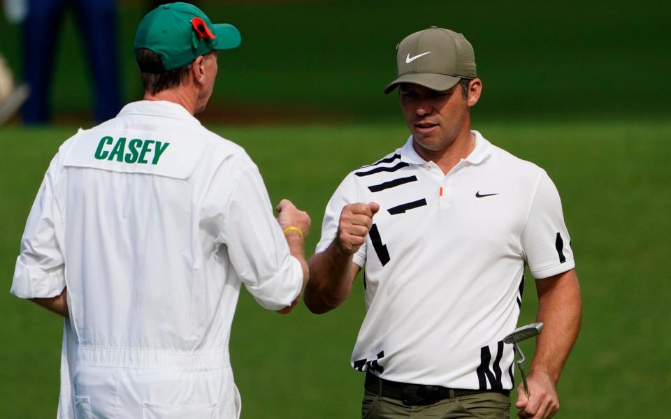Paul Casey, of England, is congratulated by his caddie after an eagle on the second hole during the first round  - AP