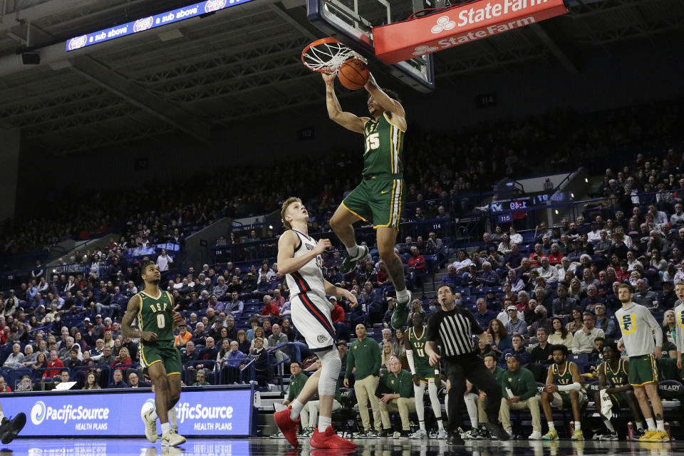 San Francisco guard Marcus Williams (55) dunks next to Gonzaga forward Ben Gregg (33) during the second half of an NCAA college basketball game, Thursday, Feb. 9, 2023, in Spokane, Wash. (AP Photo/Young Kwak)