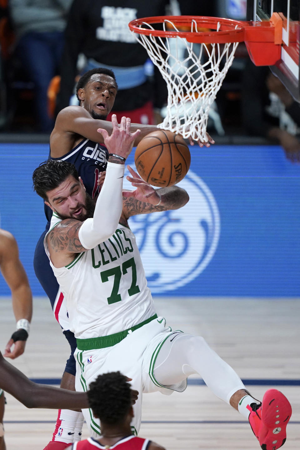 Boston Celtics' Vincent Poirier (77) and Washington Wizards' Ish Smith (14) reach for a ball during the second half of an NBA basketball game Thursday, Aug. 13, 2020 in Lake Buena Vista, Fla. (AP Photo/Ashley Landis, Pool)