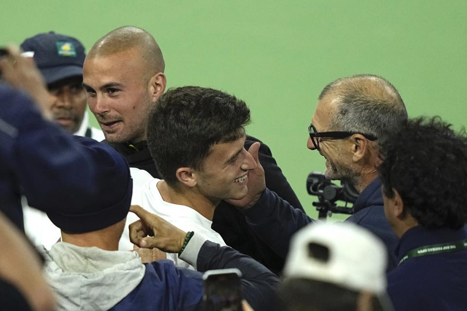 Luca Nardi, center, of Italy, hugs members of his team after upsetting Novak Djokovic, of Serbia, at the BNP Paribas Open tennis tournament Monday, March 11, 2024, in Indian Wells, Calif. Nardi won 6-4, 3-6, 6-3. (AP Photo/Mark J. Terrill)