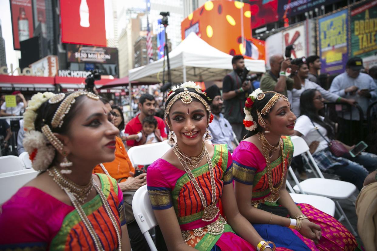 Dancers Sahana Madabhushi, left, Deeya Patel, and Harshita Shet, watch the performances during the Diwali festival at a Times Square celebration Saturday, Oct. 7, 2017, in Manhattan, New York.