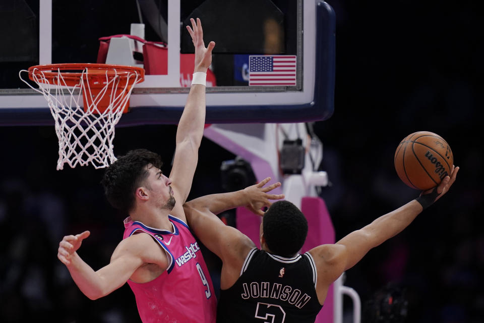 San Antonio Spurs forward Keldon Johnson (3) goes up against Washington Wizards forward Deni Avdija (9) during the first half of an NBA basketball game Friday, March 24, 2023, in Washington. (AP Photo/Carolyn Kaster)