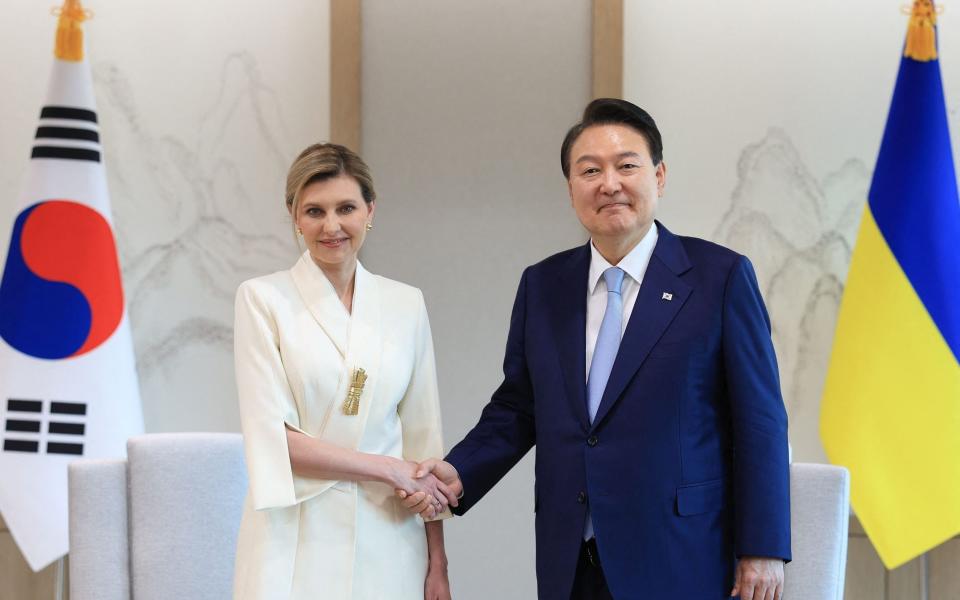 South Korean President Yoon Suk Yeol (R) shaking hands with Ukraine's First Lady Olena Zelenska - HANDOUT/AFP