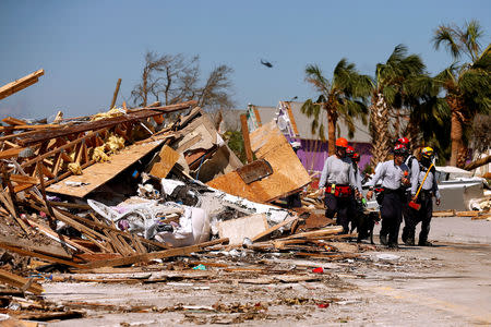 FILE PHOTO: Search and rescue crews walk past debris caused by Hurricane Michael in Mexico Beach, Florida, U.S. October 11, 2018. REUTERS/Jonathan Bachman/File Photo