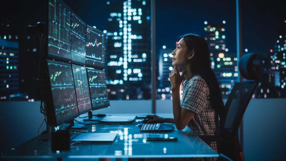 An investor looks at several trading screens in an office.