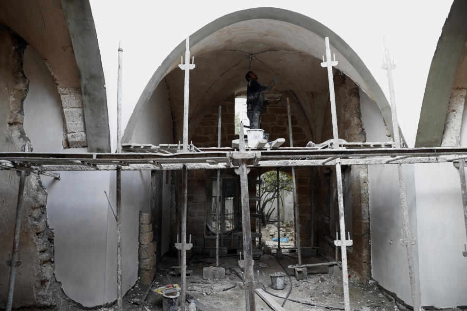 A worker renovates the long-abandoned 200-year-old Ghussein palace, in the old quarter of Gaza City, Monday, Dec. 14, 2020. Less than 200 of these old houses are still partly or entirely standing, according to officials and they are threatened by neglect, decaying and urban sprawl. (AP Photo/Adel Hana)