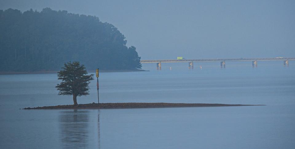 FILE - A small tree and marker with a U.S. flag are visible near State Highway 24 double bridges, as fog lays low on Lake Hartwell Friday, August 26, 2022. The body of a Florida pilot was recovered on Thursday, Sept. 15, 2022, after the plan crashed into the lake five days earlier.
