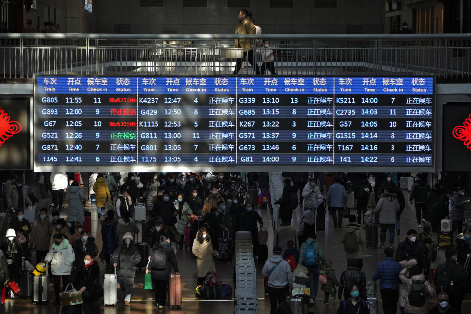 FILE - Travelers walk through a trains departure board at the West Railway Station in Beijing on Jan. 15, 2023. China has announced its first overall population decline in recent years amid an aging society and plunging birthrate. (AP Photo/Andy Wong, File)