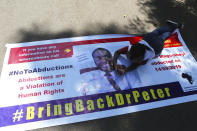 A Zimbabwean doctor lays on a banner during a protest in Harare, Wednesday, Sept, 18, 2019. Zimbabwean doctors protesting the alleged abduction of a union leader were met by a line of baton- wielding police in the capital as fears grow about government repression. (AP Photo/Tsvangirayi Mukwazhi)