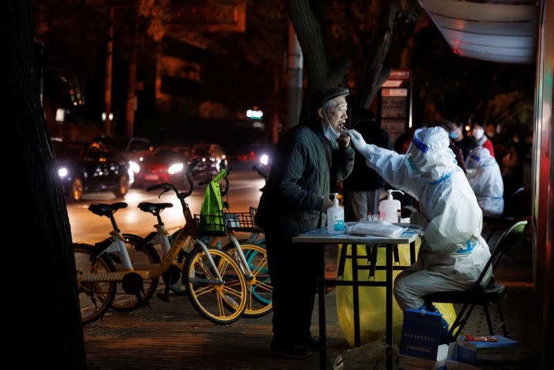 A man gets a swab tests at a temporary testing station as outbreaks of COVID-19 continue in Beijing