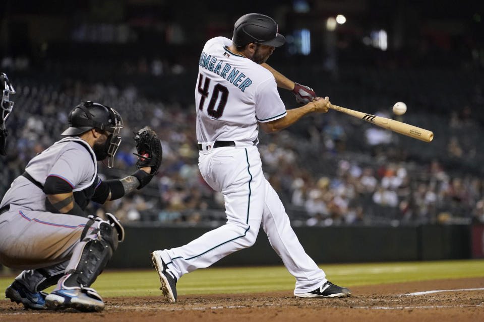 Arizona Diamondbacks' Madison Bumgarner (40) connects for a sacrifice fly during the fifth inning of a baseball game against the Miami Marlins, Tuesday, May 11, 2021, in Phoenix. (AP Photo/Matt York)