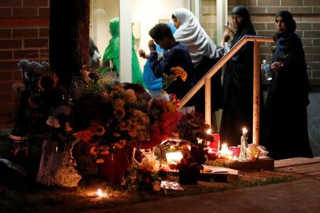 Women enter an apartment building near a memorial for Abdirahman Abdi, a Somali immigrant to Canada who died after being hospitalized in critical condition following his arrest by Canadian police, in Ottawa, Ontario, Canada, July 26, 2016. REUTERS/Chris Wattie