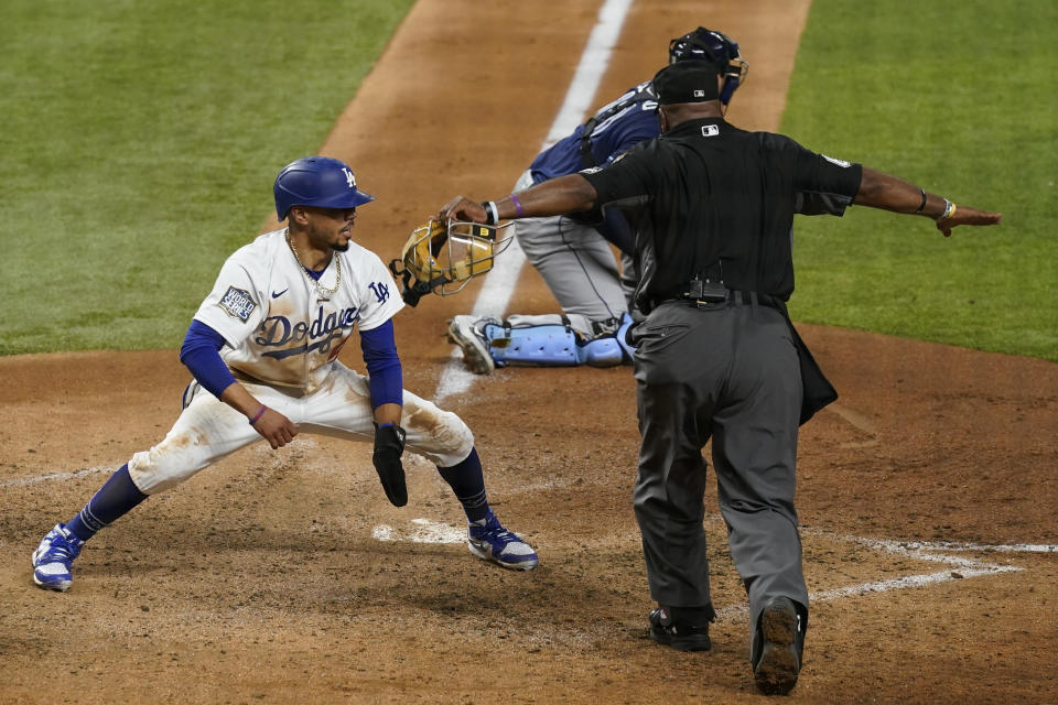 Los Angeles Dodgers' Mookie Betts scores on a fielders choice by Max Muncy during the fifth inning in Game 1 of the baseball World Series against the Tampa Bay Rays Tuesday, Oct. 20, 2020, in Arlington, Texas. (AP Photo/Eric Gay)