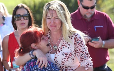 Parents wait for news after a shooting at Marjory Stoneman Douglas High School in Parkland - Credit:  Joel Auerbach/AP