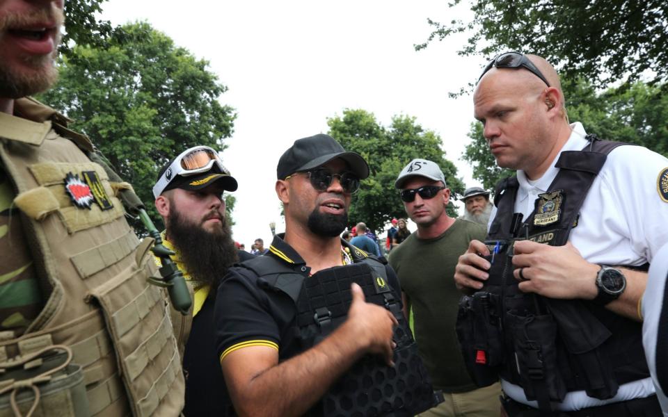 Tarrio, chairman of the alt-right group Proud Boys, speaks with a police officer during the End Domestic Terrorism rally in August 2019