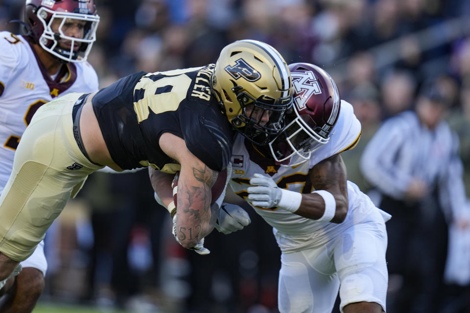 Purdue tight end Garrett Miller (88) is hit by Minnesota defensive back Tyler Nubin (27) as he scores a touchdown during the first half of an NCAA college football game in West Lafayette, Ind., Saturday, Nov. 11, 2023. (AP Photo/Michael Conroy)