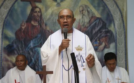 Roman Catholic priest Father Jess Siva (C) speaks during a Holy Mass next to fellow priests Father Elmer Cajilig (L) and Father Hector Canto (R) at a chapel in Lambunao, Iloilo on Panay island in central Philippines January 11, 2015. REUTERS/Erik De Castro