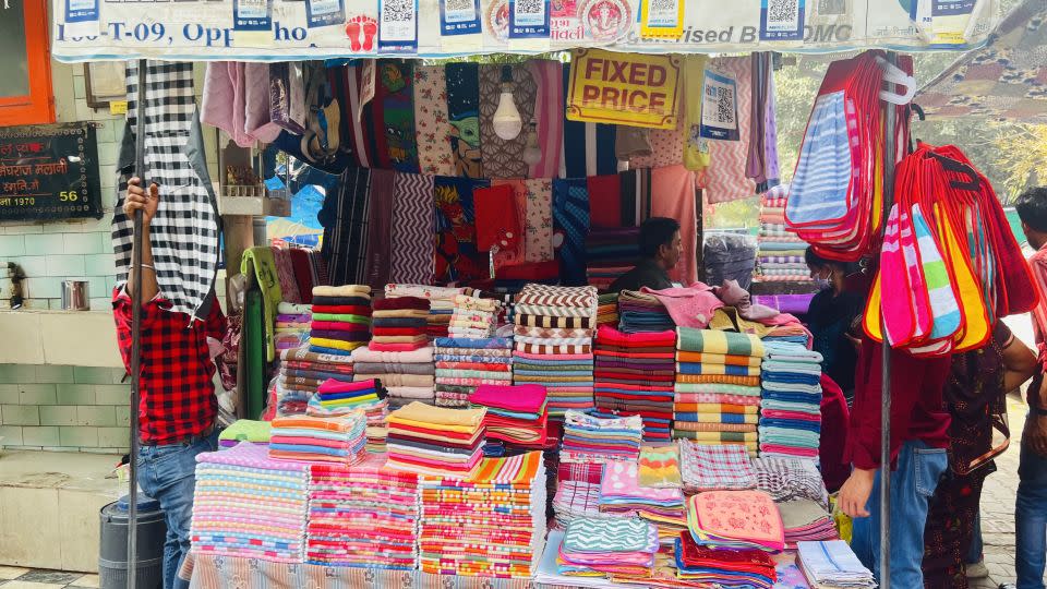 QR codes line the awning of Ramesh Kumar's towel shop at Sarojini Nagar Market in Delhi. - Sania Farooqui/CNN