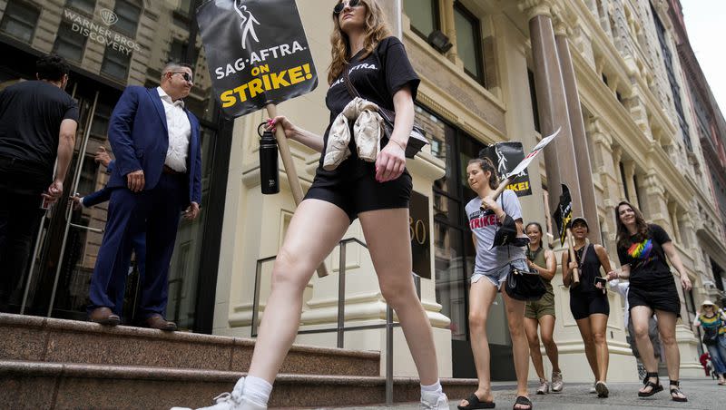 Striking writers and actors chant as they walk a picket line outside the Warner Bros. Discovery officers, Monday, July 17, 2023, in New York. Nearly four months later, a tentative agreement has been met between the SAG-AFTRA and Hollywood studios on Nov. 8, 2023.