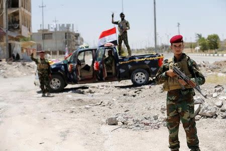 Iraqi government forces react to the camera in Falluja after government forces recaptured the city from Islamic State militants, Iraq, July 1, 2016. REUTERS/Thaier Al-Sudani