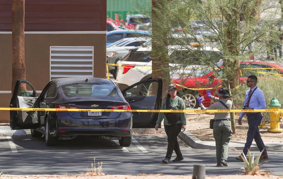 Investigators document the scene in front of the SpringHill Suites by Marriott where two people were slain in the parking lot of the building in Palm Desert, Calif., July 15, 2022.