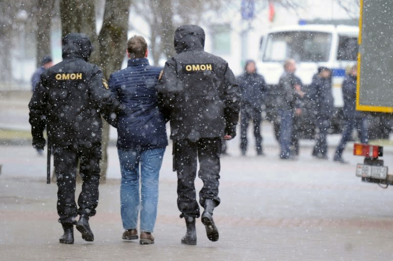 Police officers detain a man as opposition supporters gather for a rally against President Alexander Lukashenko's rule and a controversial new tax on "spongers" - those who work less than six months a year - in Minsk on March 25, 2017