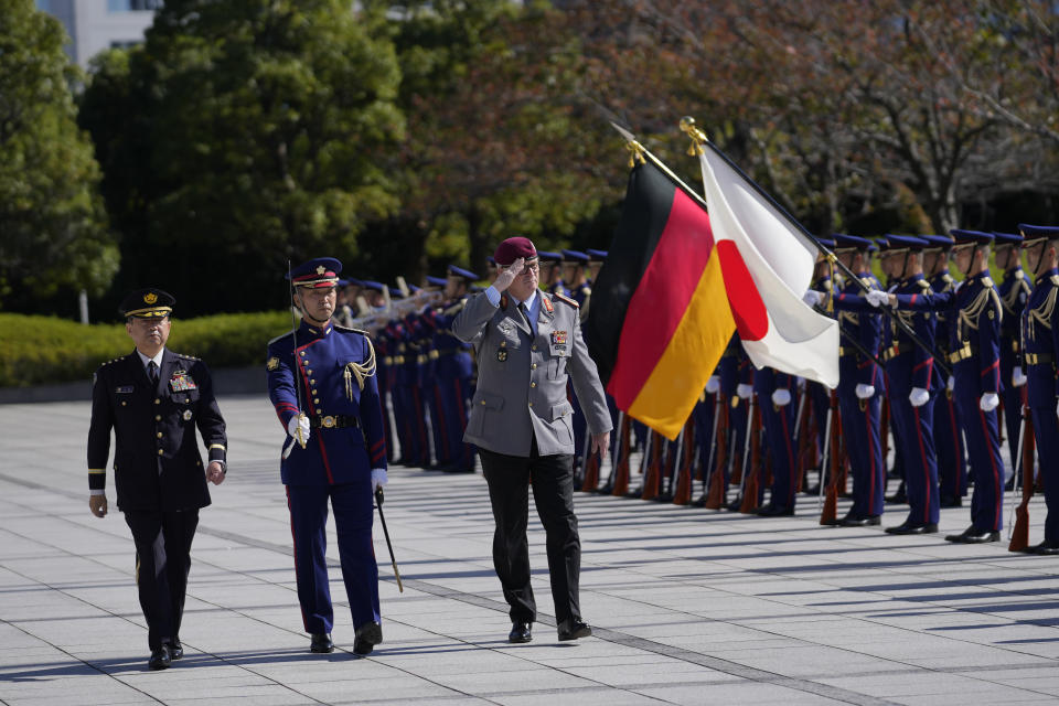 Gen. Eberhard Zorn, chief of defense of the German Armed Forces, center, salutes as he and Gen. Koji Yamazaki, left, chief of Staff, Joint Staff of the Japan Self-Defense Forces, observe an honor guard at the Ministry of Defense in Tokyo, Friday, Nov. 5, 2021. (AP Photo/Hiro Komae)