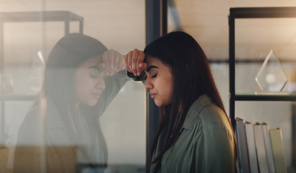 woman looking out the window sadly in an office