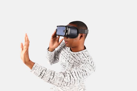 Man wearing Gear VR on his head and holding his hand out