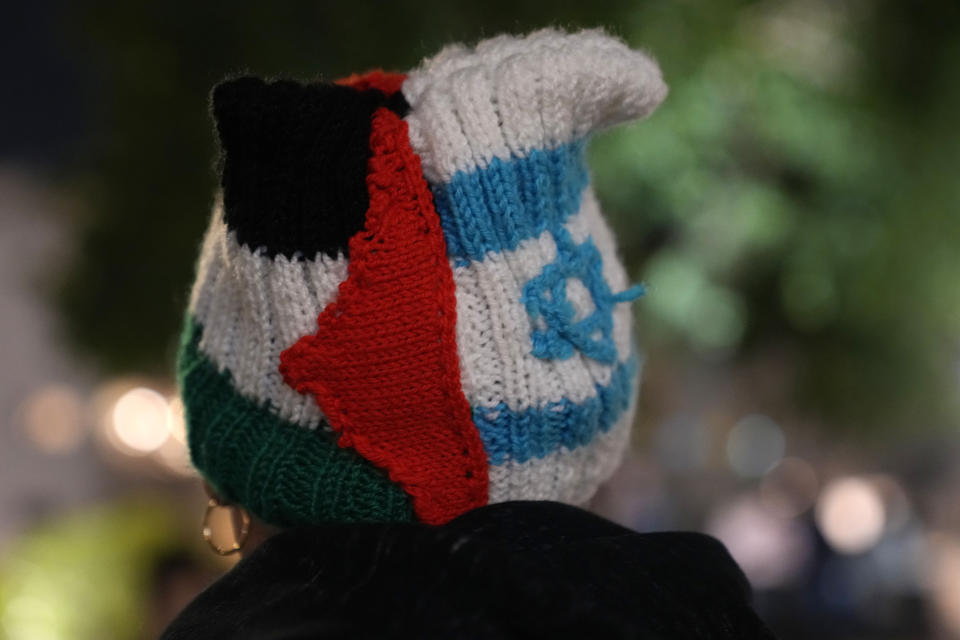 A person wears a knit cap in the colors of the Palestinian and Israeli flags in Tel Aviv, Israel, during a protest against Prime Minister Benjamin Netanyahu's far-right government, Saturday, Jan. 7, 2023. Thousands of protesters turned up, days after the most right-wing and religiously conservative government in the country's 74-year history was sworn in. (AP Photo/ Tsafrir Abayov)