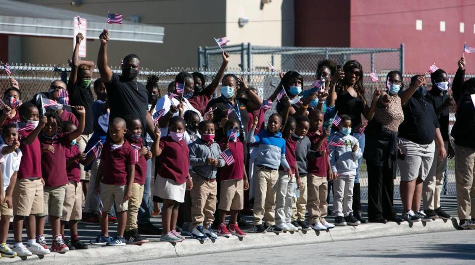 Students and staff at Carrie P Meek/Westview K-8 Center wave flags and pay respects to the late-Congresswoman Carrie Meek. The funeral procession for Meek drove past the school Tuesday morning, Dec. 7, 2021.