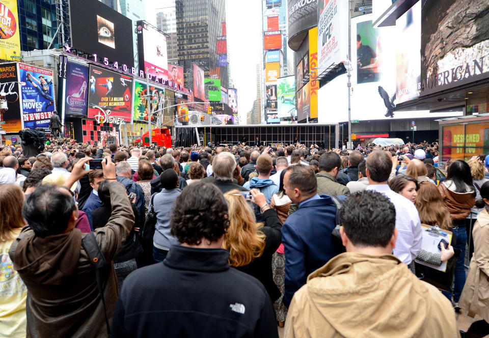 People gather to see Paul McCartney and his band give a surprise pop up concert in Times Square on Thursday, Oct. 10, 2013 in New York. McCartney will release his new album called "New" on October 15. (Photo by Evan Agostini/Invision/AP)