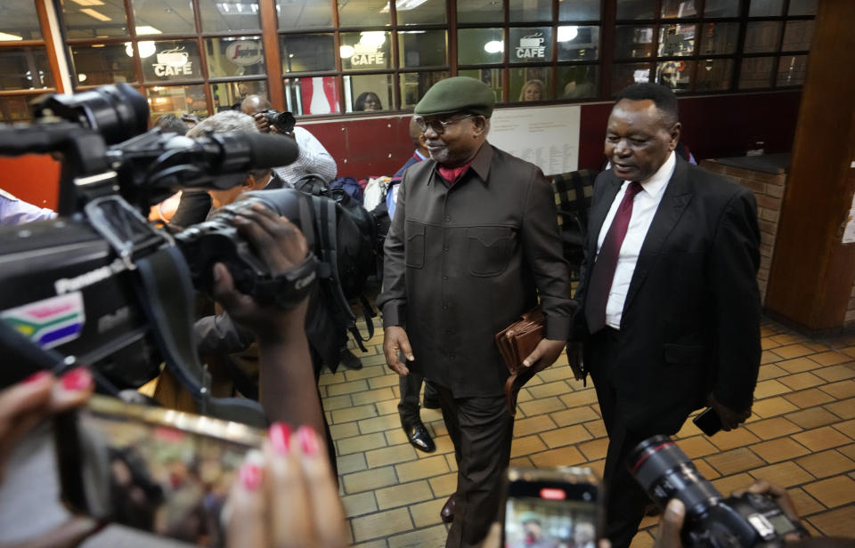 Husband of South Africa's parliament former speaker, Nosiviwe Mapisa-Nqakula, Charles Ngakula, left, arrives at the magistrates court in Pretoria, South Africa, Thursday, April 4, 2024. Mapisa-Nqakula is to be charged for receiving about $135,000 in bribes from a defense contractor during her three years as defense minister. (AP Photo/Themba Hadebe)