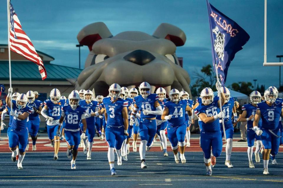 The Folsom Bulldogs run onto the field before the game against the Oak Ridge Trojans on Friday, Sept. 29, 2023, at Folsom High School in Folsom.
