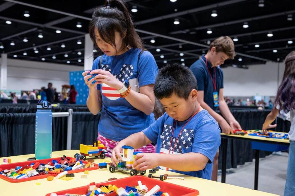 Shin Liu builds a car with her son Cedric, 5, to race at the Brick Fest Live on Sunday, Oct. 2, 2022, at SAFE Credit Union Convention Center in downtown Sacramento.