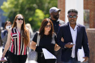 Former NFL players Ken Jenkins, right, and Clarence Vaughn III, center right, along with their wives, Amy Lewis, center, and Brooke Vaughn, left, carry tens of thousands of petitions demanding equal treatment for everyone involved in the settlement of concussion claims against the NFL, to the federal courthouse in Philadelphia, Friday, May 14, 2021. Thousands of retired Black professional football players, their families and supporters are demanding an end to the controversial use of “race-norming” to determine which players are eligible for payouts in the NFL’s $1 billion settlement of brain injury claims, a system experts say is discriminatory. (AP Photo/Matt Rourke)