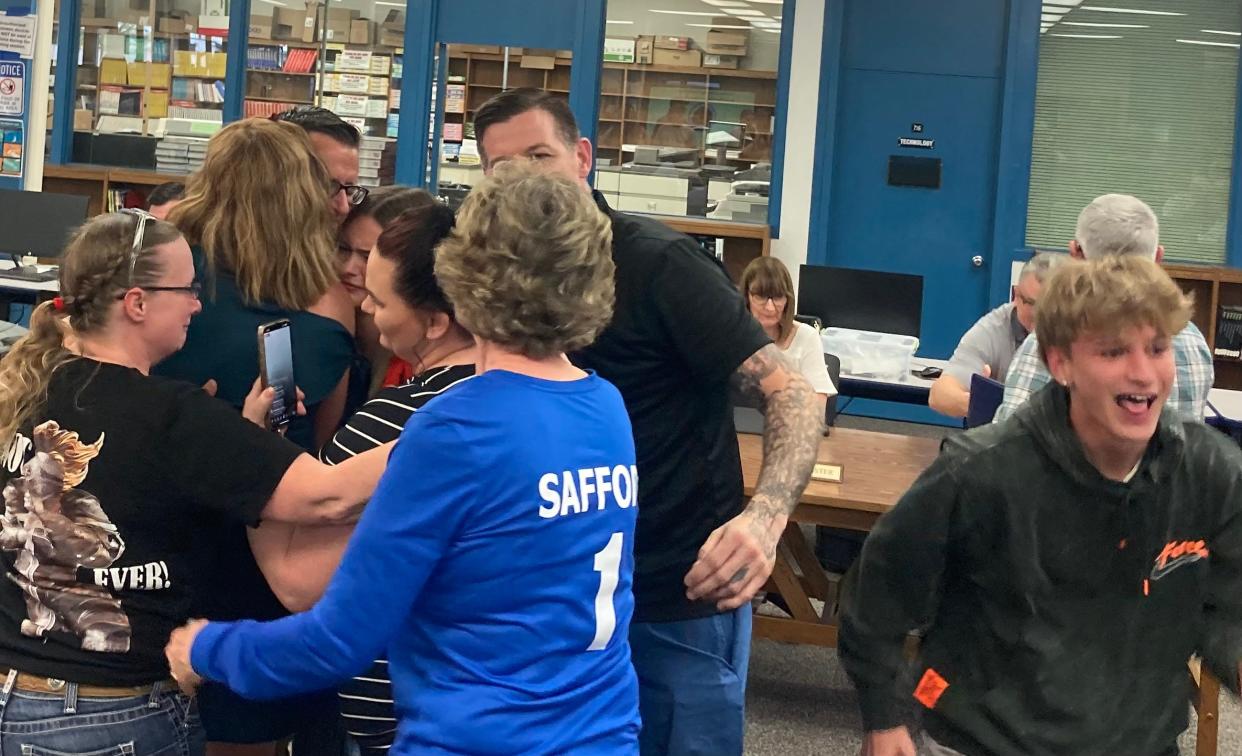 Thomas Safford is surrounded by friends and family Friday after the Anderson Union High School District Board of Trustees agreed to reinstate him as principal at Anderson High School.