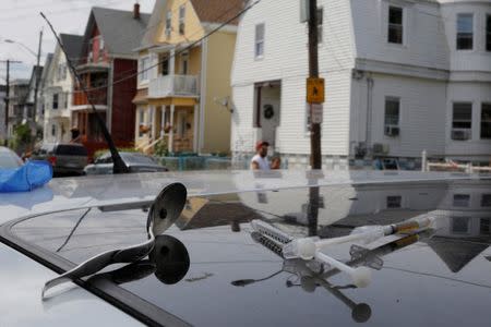 FILE PHOTO: A syringe filled a narcotic, an empty syringe and a spoon sit on the roof of a car, where a man in his 20's overdosed on opioids in Lynn, Massachusetts, U.S., August 14, 2017. Picture taken August 14, 2017. REUTERS/Brian Snyder