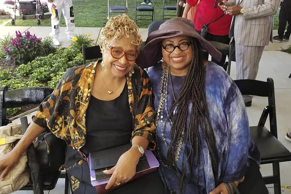 In this 2019 photo provided by Marsha Battle Philpot, Philpot, right, widely known by her moniker Marsha Music and Brenda Perryman pose for a photo at the groundbreaking ceremony for the Motown Museum expansion in Detroit. As the coronavirus tightened its grip across the country, it is cutting a particularly devastating swath through an already vulnerable population, black Americans. The coronavirus deaths in Detroit include educator and playwright Perryman and Gloria Smith, who was a staple at the city’s African World Festival and died within a week of her husband. (Marsha Battle Philpot via AP)