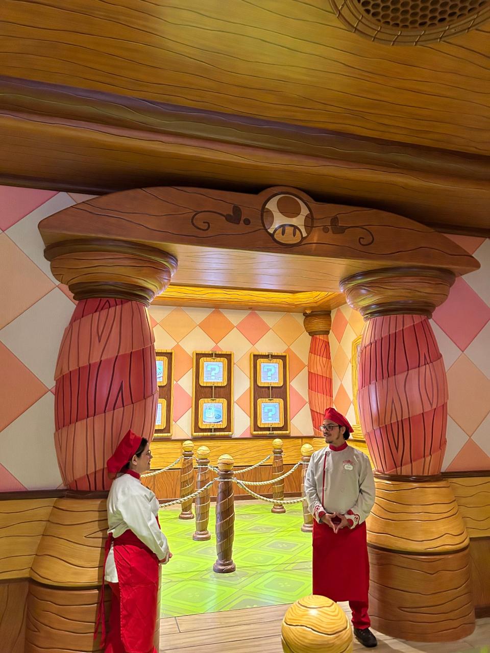 Workers standing at the entrance of the ordering area at the Toadstool Cafe to help with line control