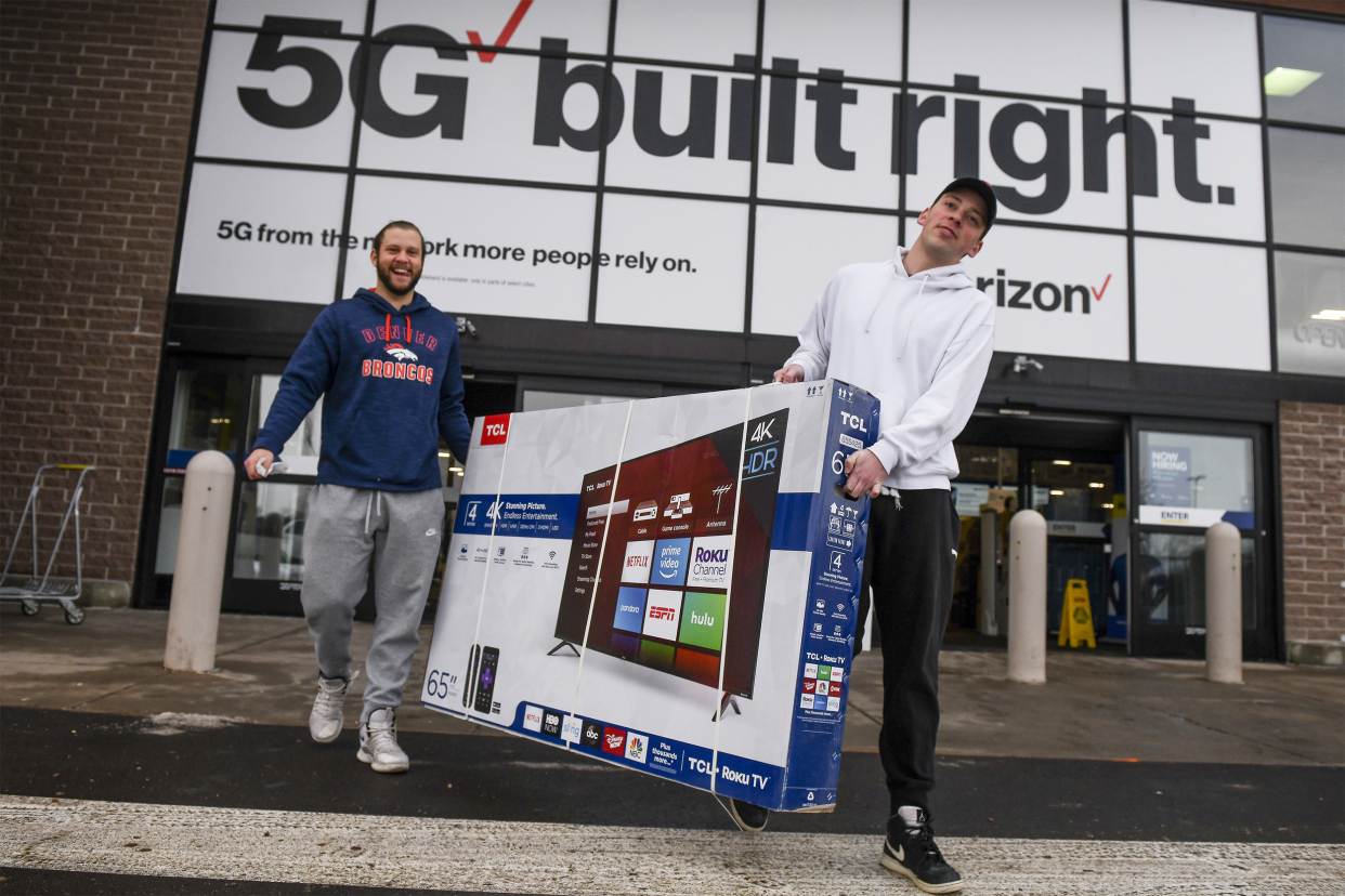 Brothers Cody Dunham, left, and William Dunham carry a television out of Best Buy after it opened to Black Friday shoppers