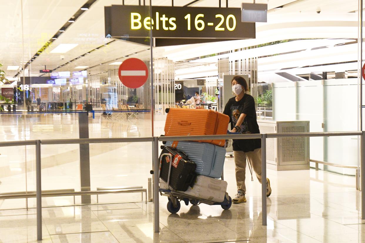 A traveller comes out of the arrival hall after landing at Singapore Changi Airport. 