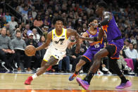 Utah Jazz guard Collin Sexton (2) drives past Phoenix Suns guard Cameron Payne (15) and center Deandre Ayton during the first half of an NBA basketball game, Saturday, Nov. 26, 2022, in Phoenix. (AP Photo/Rick Scuteri)